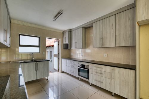 Free Contemporary kitchen featuring sleek wooden cabinets and stainless steel appliances. Stock Photo