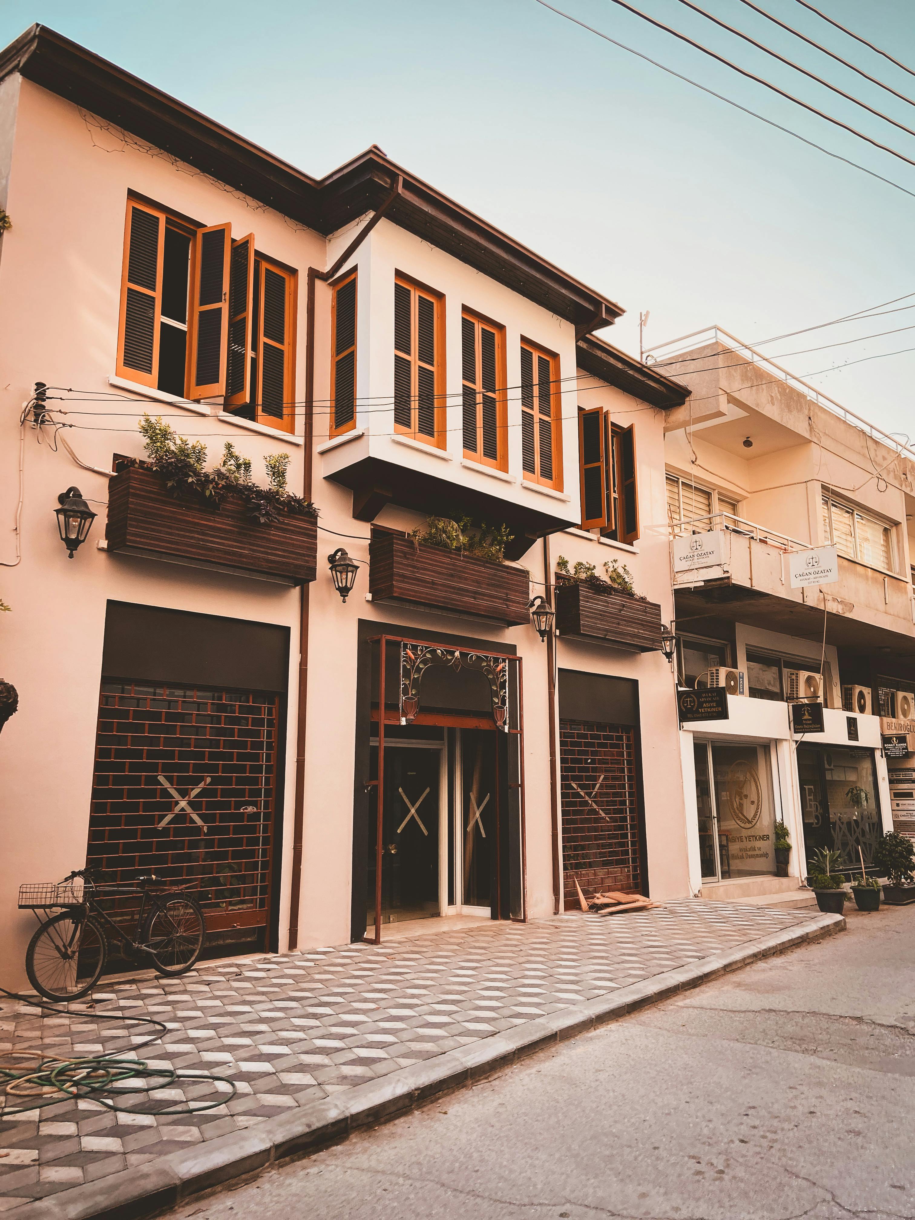 Modern urban architecture in a sunny Nicosia street with a bicycle parked outside a building.