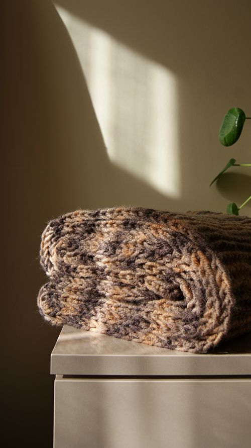 Folded chunky wool throw in sunlight — photo by Dilara Hazıroğlu on Pexels