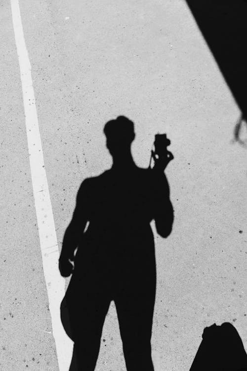 Shadow on the Road of a Man Holding a Camera