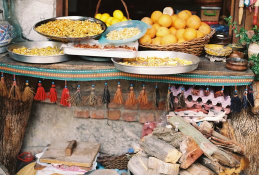 Decorative rustic display with citrus fruits and dried goods on a traditional setting.