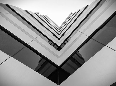 Dramatic black and white shot of a futuristic building with geometric lines and windows.