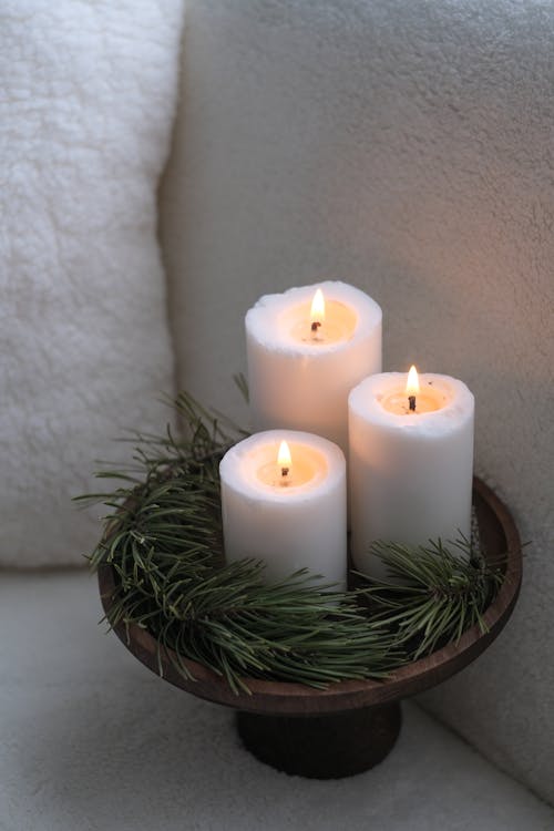 Burning Candles on a Wooden Tray with Pine Branches