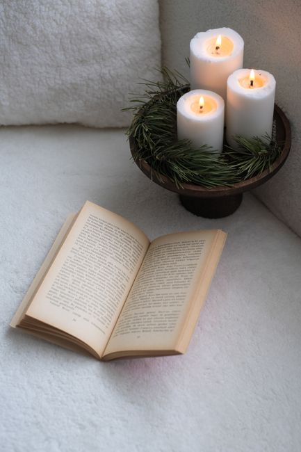 A serene setup featuring a book and lit candles on a cozy surface, perfect for relaxation.