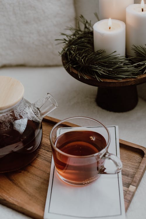 Cup of Delicious Tea by Decoration with Needle Branches and White Candles