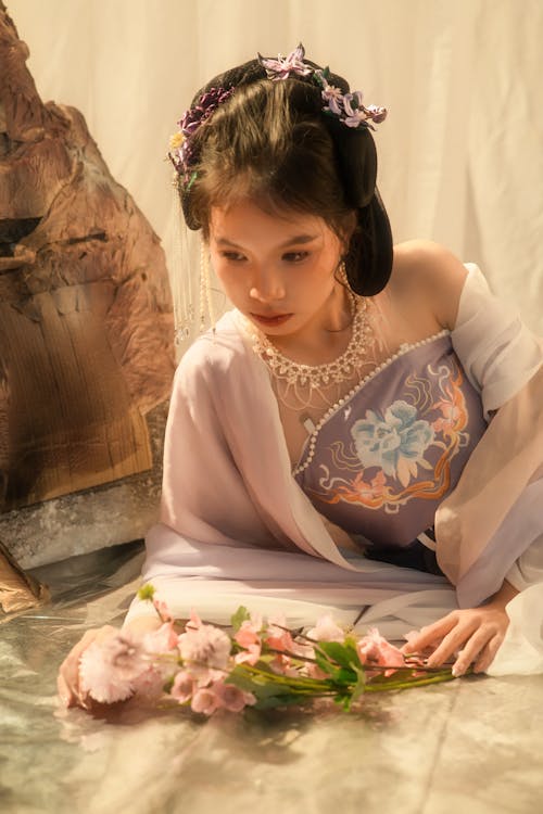 Beautiful Woman in Pink Dress Posing by Bouqurt of Flowers on Floor