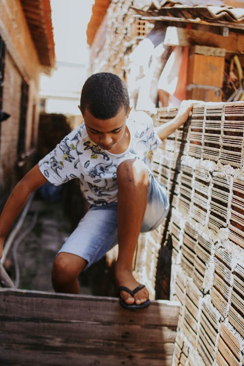 Boy Climbing over Wooden Fence