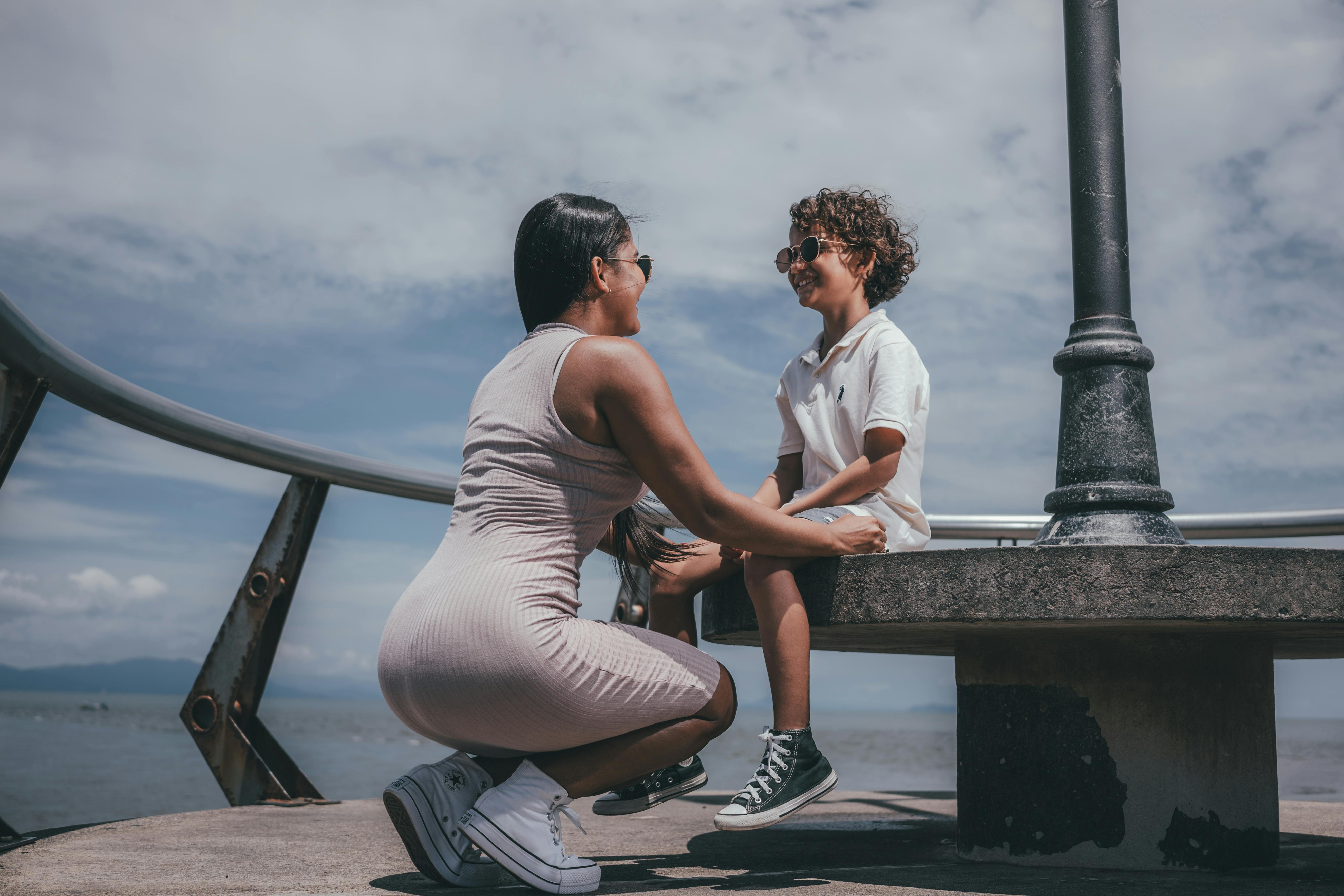 woman sitting on a pier with her son and smiling