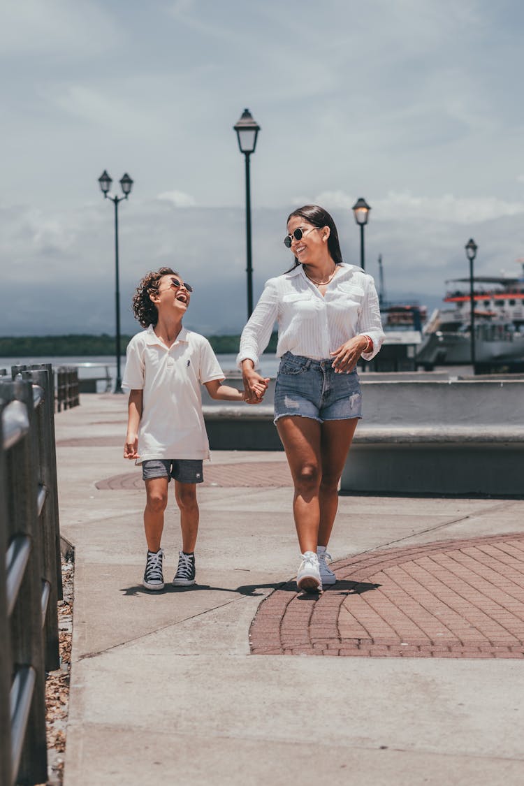 Smiling Mother With Laughing Child Walking On The Promenade