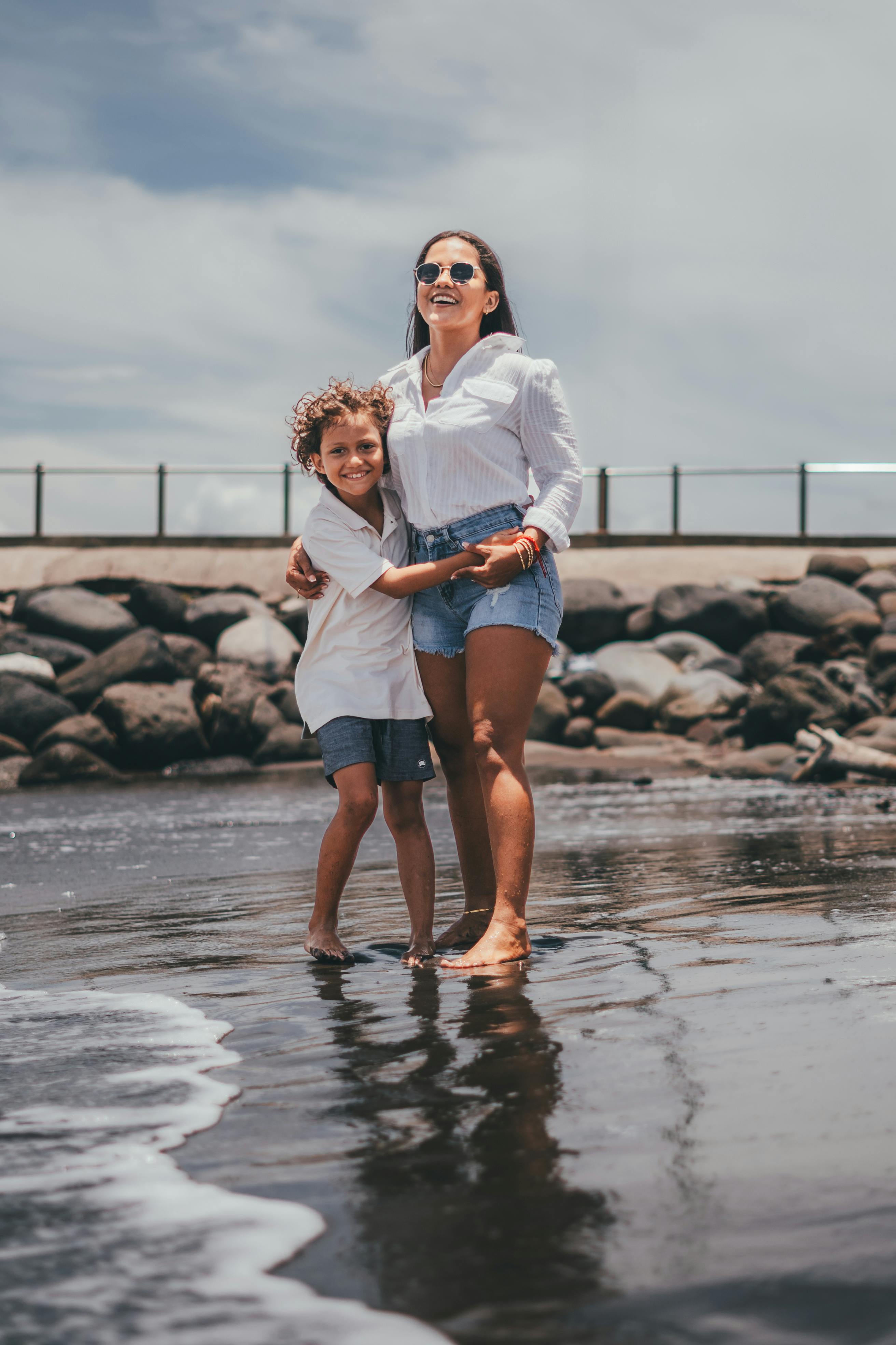 woman with her son standing ankles deep in water and smiling