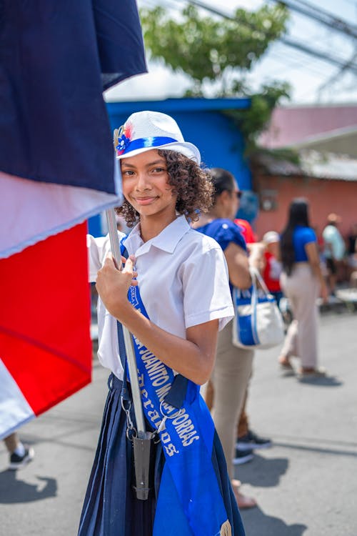 Woman in White Shirt Standing on Street with Costa Rican Flag in Hands