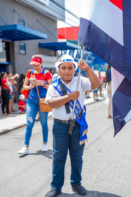 A Schoolboy Standing with a Flag on the Street in the Independence Day Parade in Costa Rica