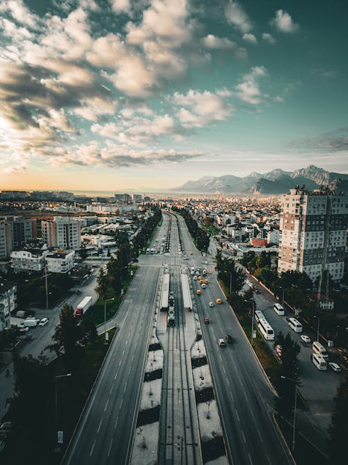 Drone Shot of a Street and Buildings in City with View of Mountains in Distance 