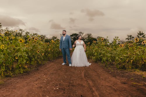 Bride and Groom Standing on a Sunflower Field 