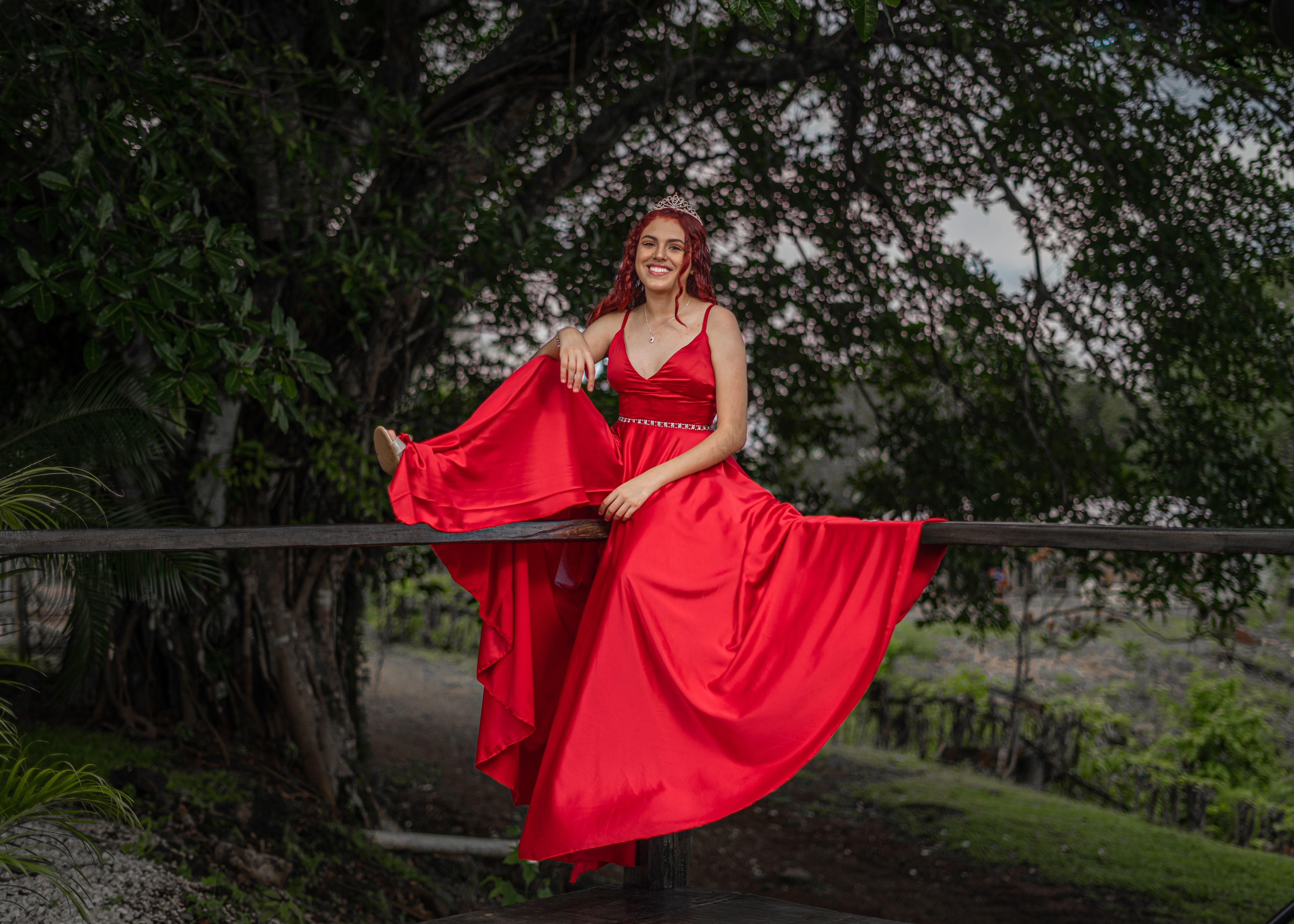 Young Woman in a Red Dress Sitting on a Fence · Free Stock Photo