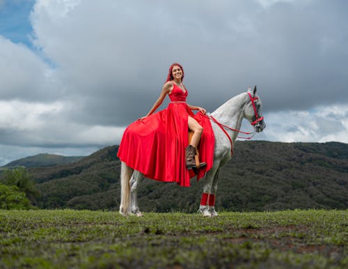 Portrait of a Young Woman Wearing a Red Evening Gown Sitting on a Horse