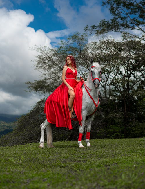 Portrait of a Young Woman Wearing a Red Evening Gown Sitting on a Horse