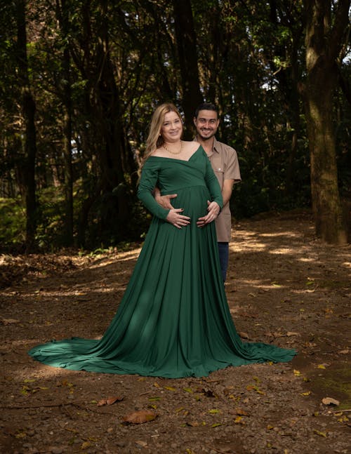 Portrait of a Pregnant Couple Posing Together in a Forest