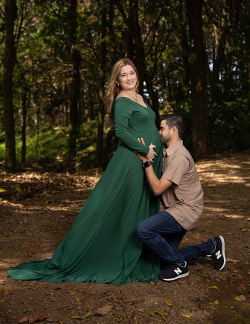 Portrait of a Pregnant Couple Posing Together in a Forest