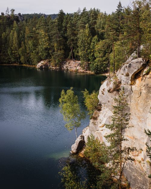 Free Tranquil landscape of Piskovna Lake with surrounding forest and rocky cliffs in the Czech Republic. Stock Photo