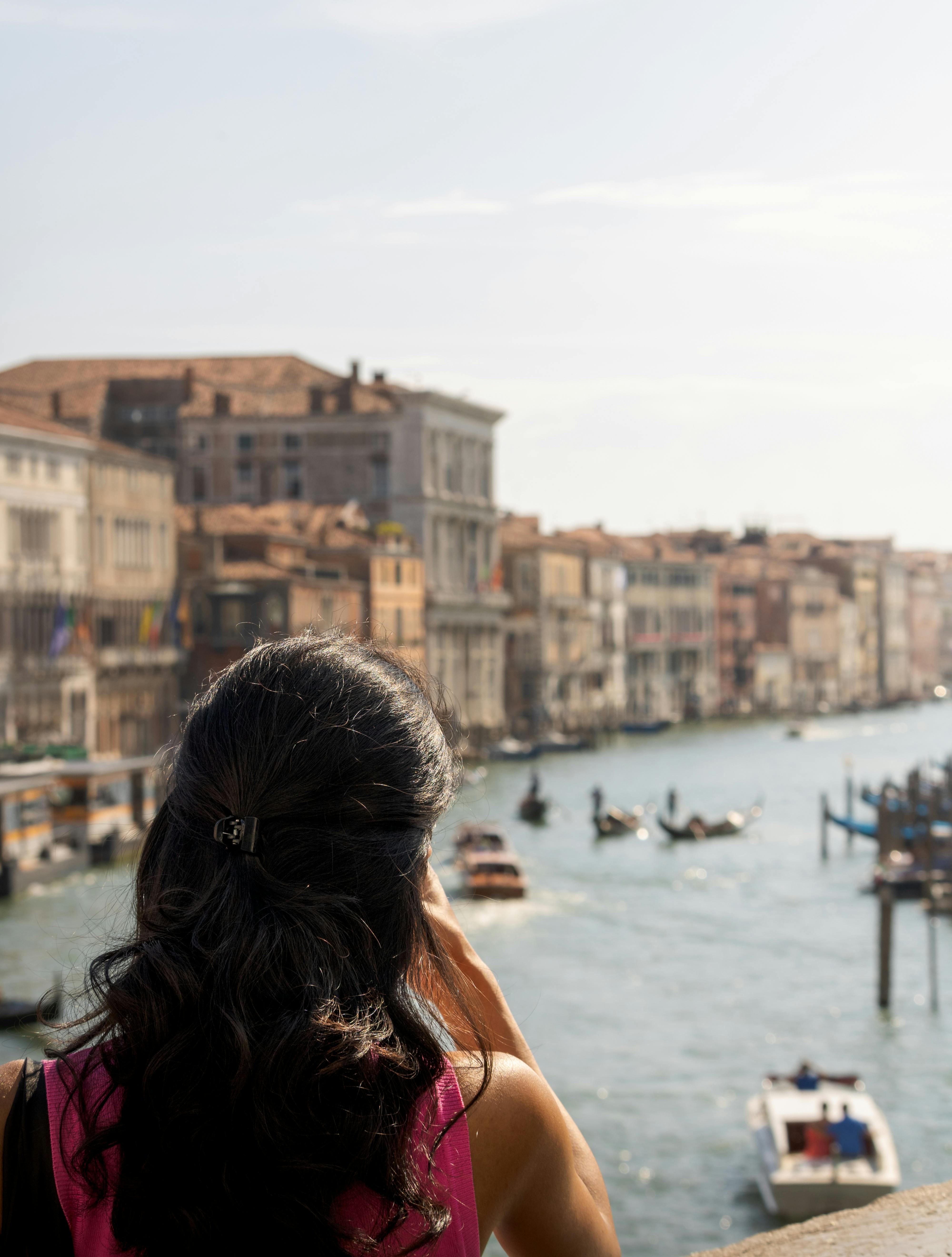 a woman is looking at the water from a balcony