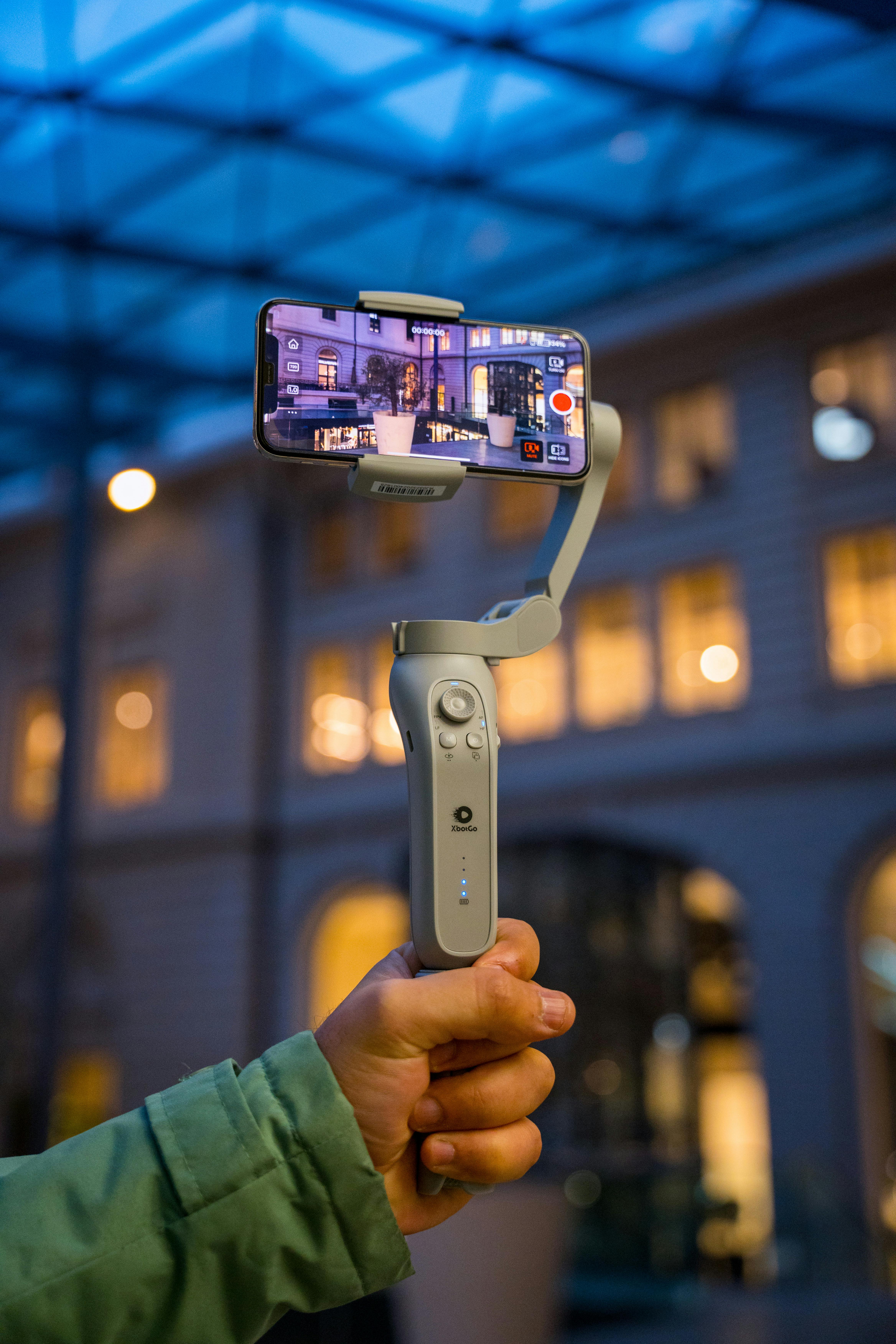 hand holding gimbal with smartphone and recording video