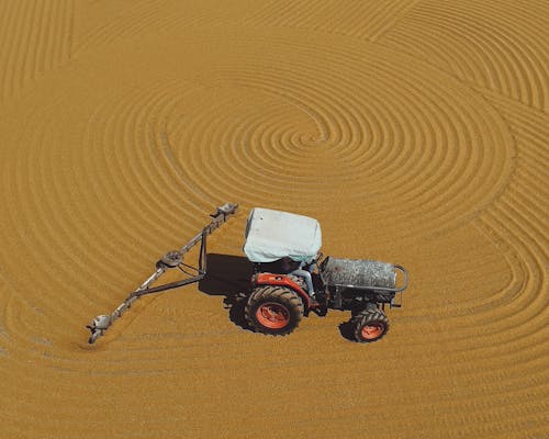 Drone Shot of a Tractor Driving on a Field 