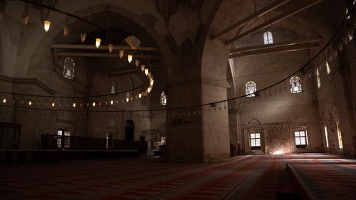 Free Explore the serene and majestic interior of a historic mosque, highlighting chandeliers and arches. Stock Photo