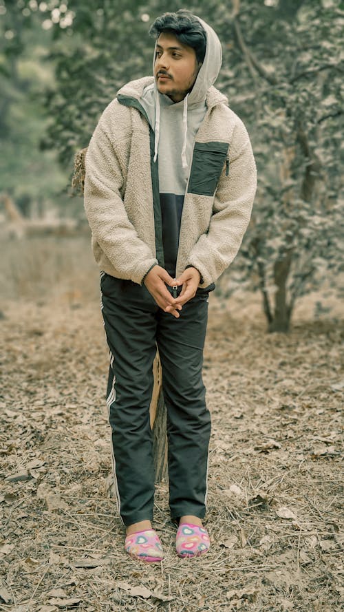 Young Man in a Sherpa Jacket and Pink Slippers in the Forest