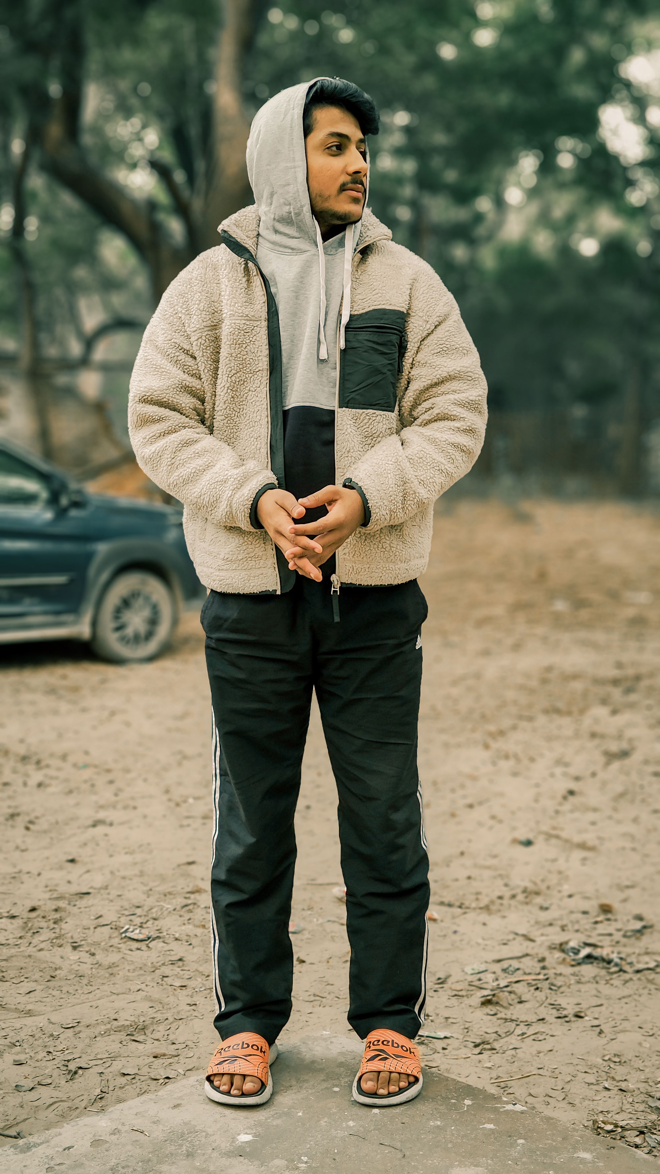Casual fashion photo of a young man standing outdoors in a sherpa jacket.