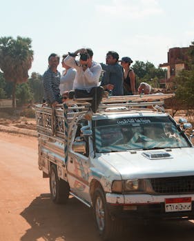 A group of travelers enjoy a ride on a truck in Luxor, Egypt under a clear sky.