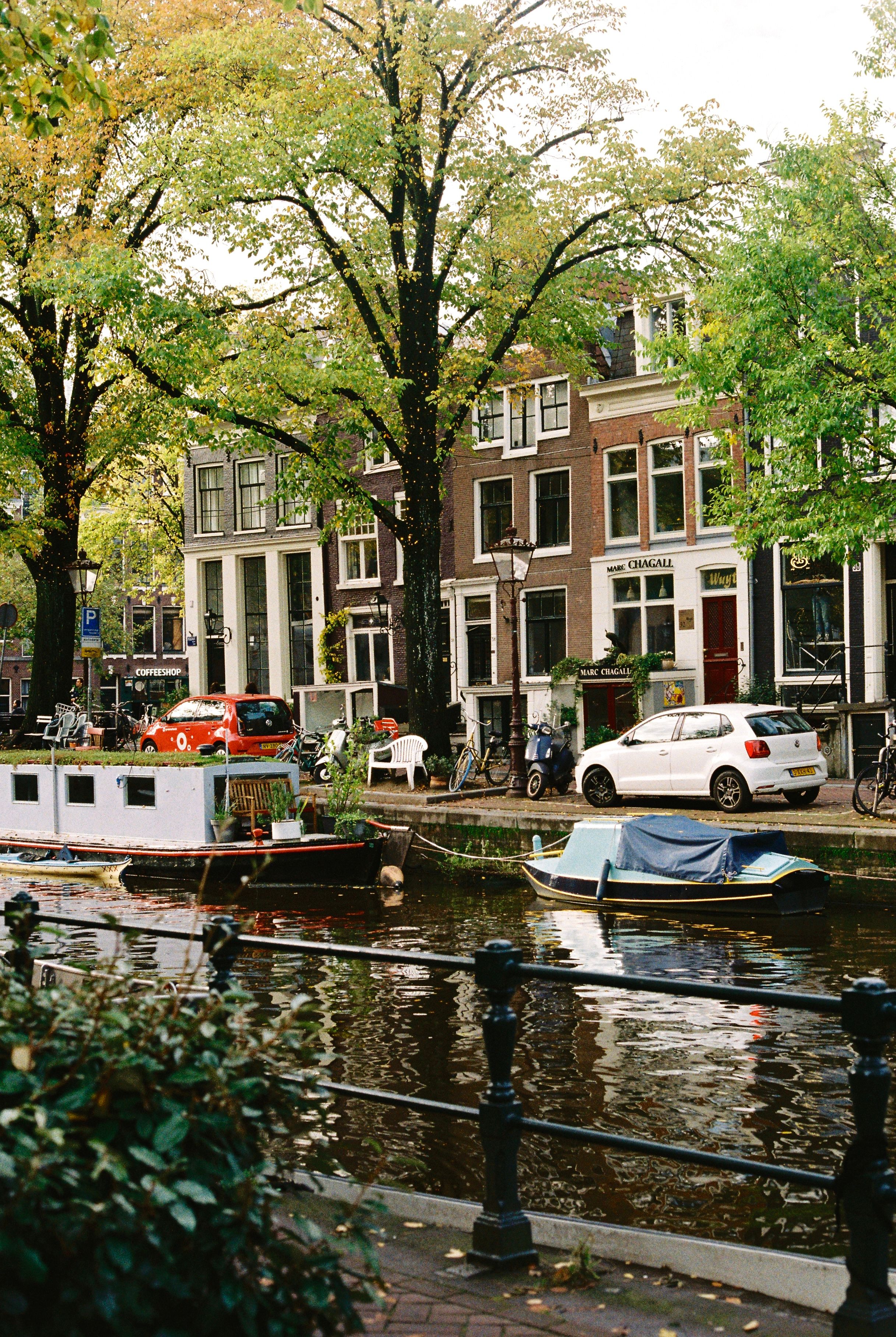 A picturesque view of Amsterdam's iconic canals with boats and classic architecture.