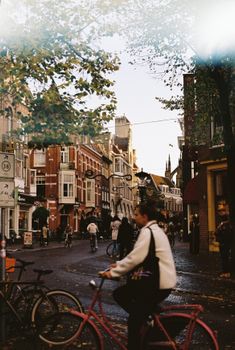 Bicyclists navigate the charming streets of Utrecht, Netherlands, during a vibrant day.