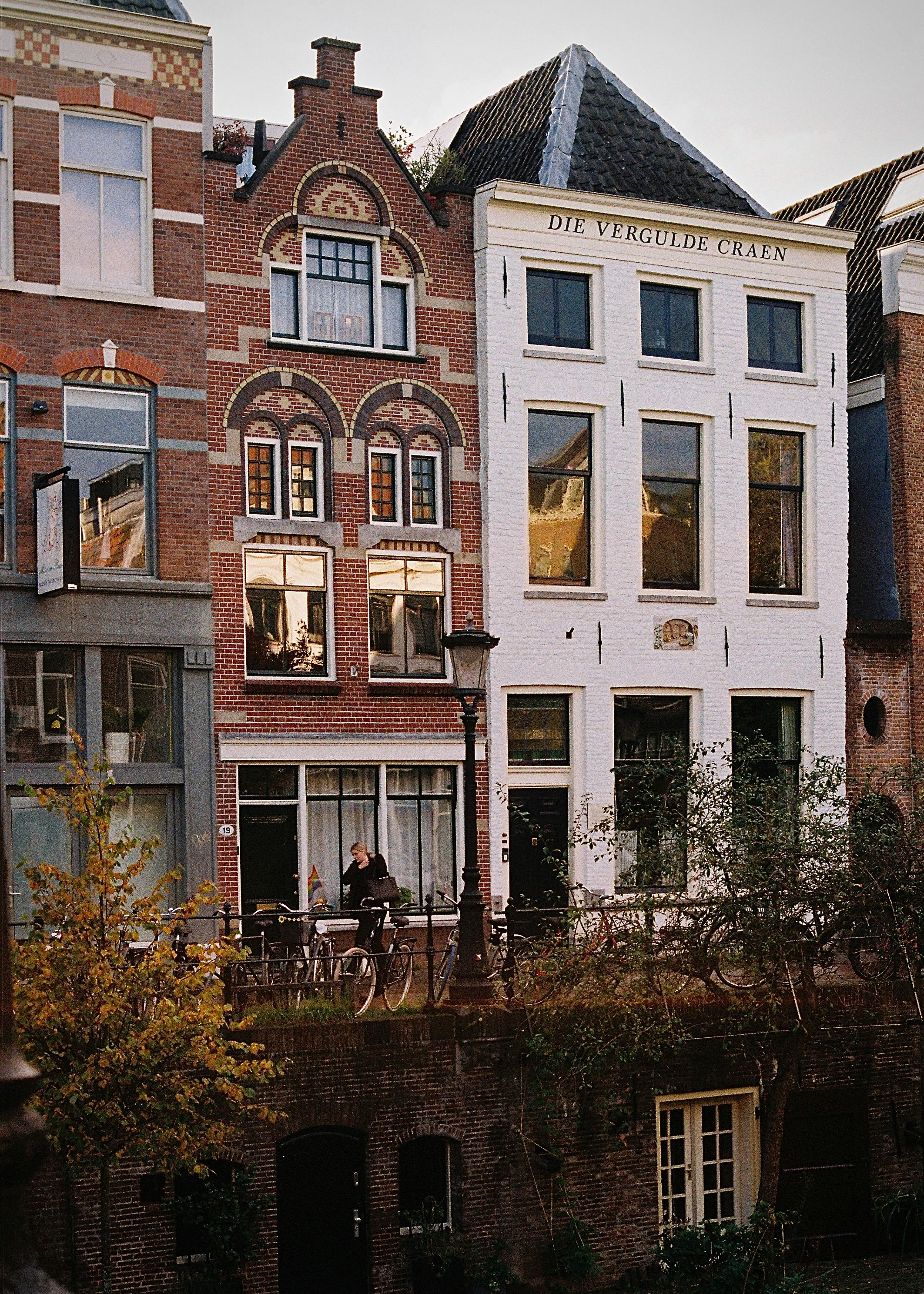 Stunning view of traditional Dutch architecture along Amsterdam canal, featuring historic brick facades and bicycles.