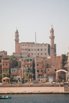 A beautiful view of Louxor's traditional architecture along the Nile River, showcasing historical structures and urban life.