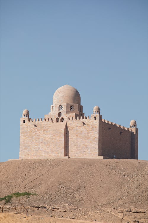 A large stone building with two domes on top of a hill