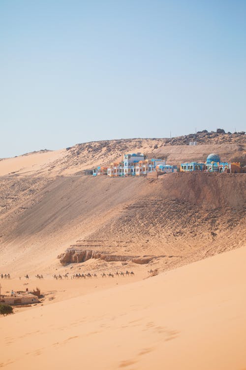 A desert with a blue house in the middle