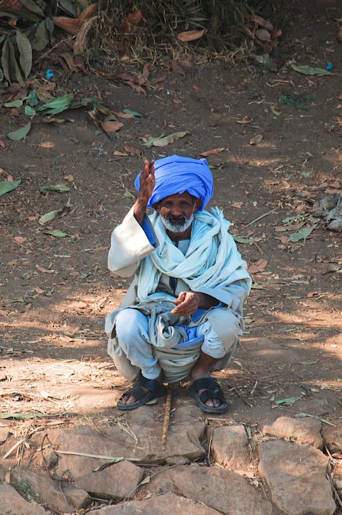 A man in a turban sitting on the ground