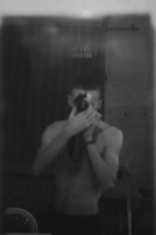 Free Artistic black and white self-portrait of a man capturing his reflection in a mirror. Stock Photo