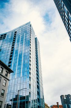 Tall modern skyscrapers with glass facades in an urban setting on a clear day.