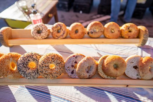 A variety of fresh bagels on a wooden tray at a market in Arcata, CA.