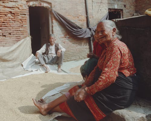 Free An old woman sitting on a pile of rice Stock Photo