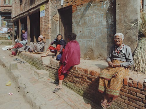 People Sitting on Wall in Village