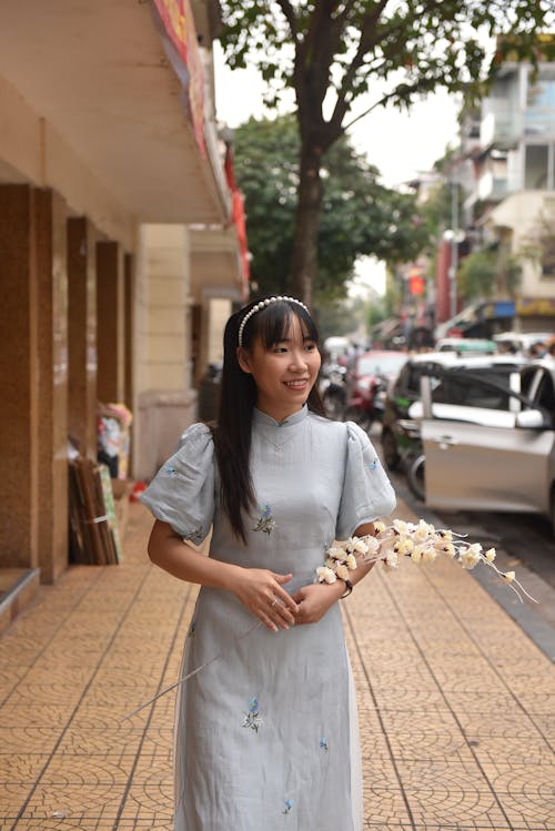 Model in Dress posing with Flowers in City