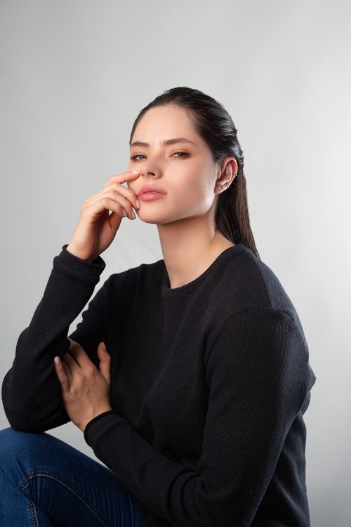 Free A thoughtful young woman in casual fashion poses indoors in Nogales, Mexico. Stock Photo