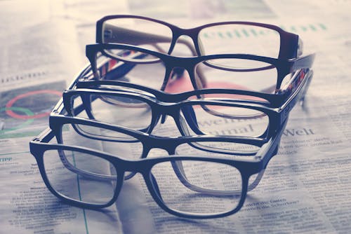 Free Close-up of Pairs of Eyeglasses Lying on a Newspaper  Stock Photo