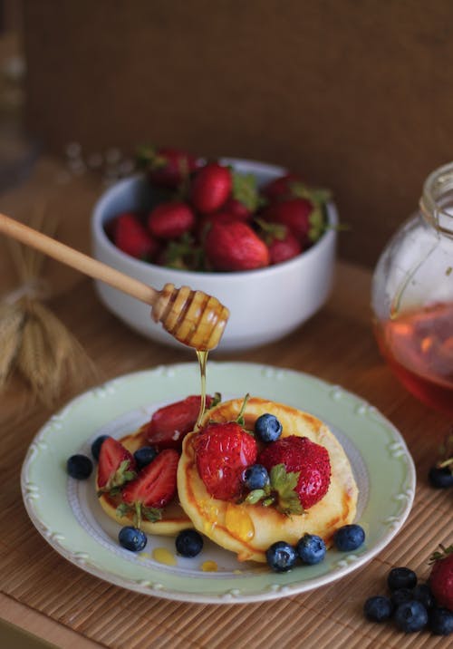 Free Close-up of Person Putting Honey on Pancakes  Stock Photo