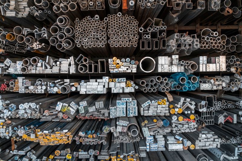Metal bars, pipes and tubing stored on warehouse racks