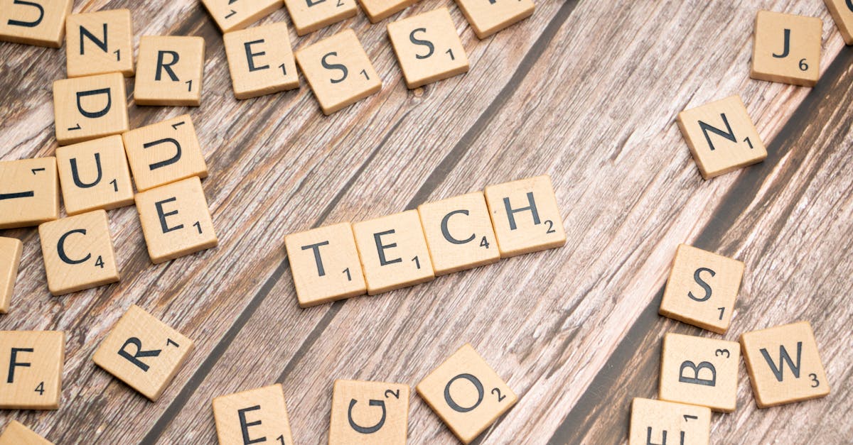 Scrabble letters spelling out tech on a wooden table · Free Stock Photo