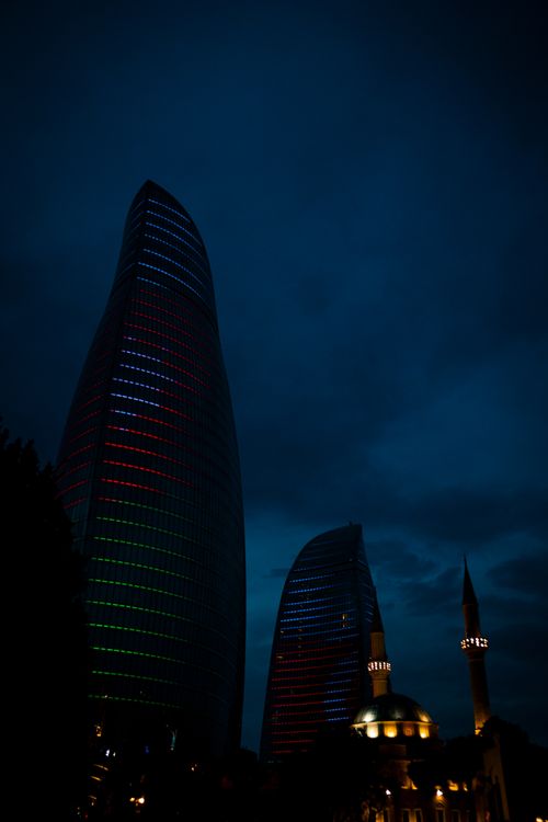 Free Captivating nighttime cityscape of Baku with Flame Towers and mosque silhouettes. Stock Photo